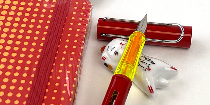 lamy_2022_special_edition_glossy_red_al_star_fountain_pen_and_notebook_with_lucky_cat_pen_rest