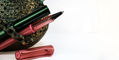 lamy_special_edition_al_star_flamingo_and_pine_rollerball_pens_one_uncapped_with_bucket