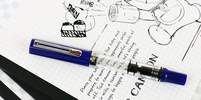 twsbi_eco_dark_sapphire_fountain_pen_capped_on_black_and_white_notebook