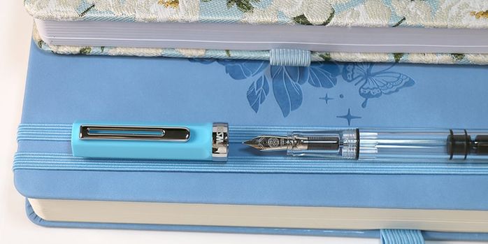twsbi_eco_sky_blue_fountain_pens_on_blue_notebook