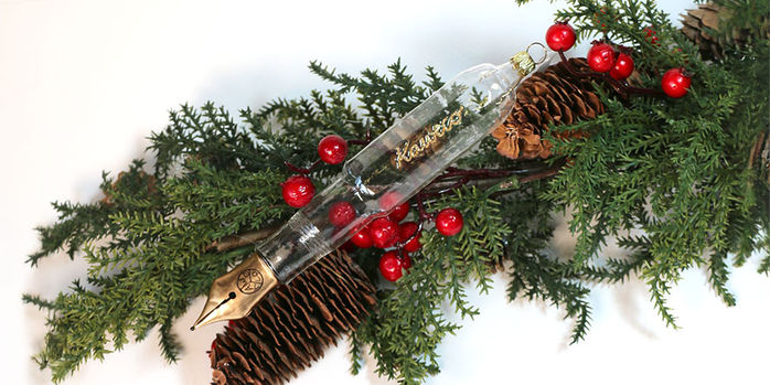 kaweco_2024_clear_blown_glass_ornaments_on_greenery