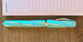 visconti_divina_elegance_wave_rollerball_pen_capped_by_notepad