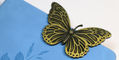 brass_page_holders_painted_lady_butterfly_bookmarks_on_notebook