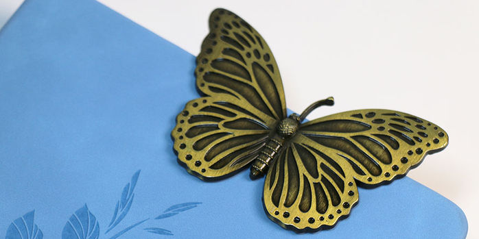 brass_page_holders_painted_lady_butterfly_bookmarks_on_notebook