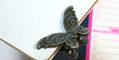 brass_butterfly_binder_clips_on_notebook
