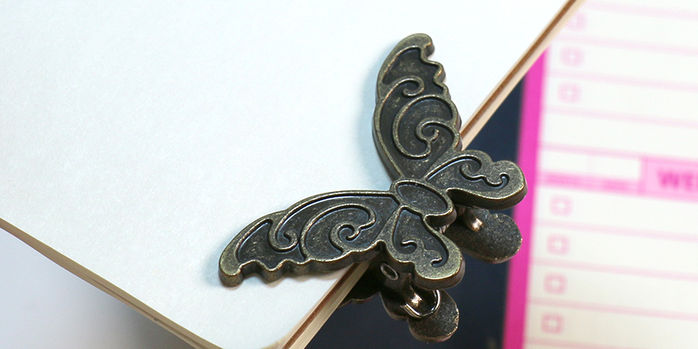 brass_butterfly_binder_clips_on_notebook