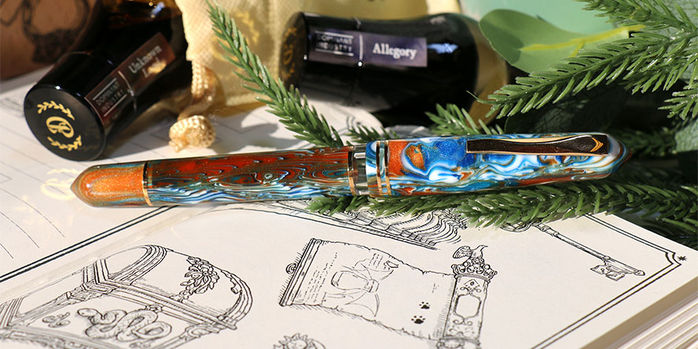 Gioia_x_dominant_industry_alchemist_elixir_boxed_set_log_of_elixir_fountain_pen_with_gold_trim_on_Book